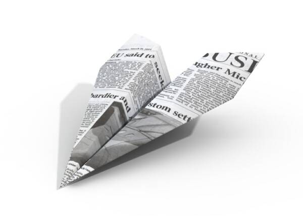 Newspaper folded as a paper airplane